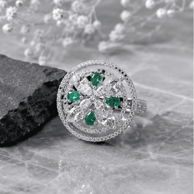 Close-up angled view of the Emerald Halo Bloom adjustable silver ring highlighting the floral design and brilliant stone detailing.