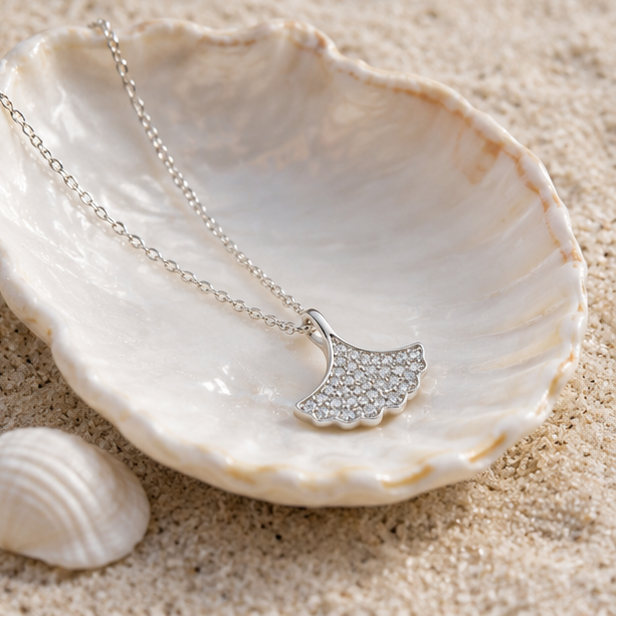 Close-up of the Écaille Lumière sterling silver shell pendant showcasing sparkling pavé detailing and polished finish.