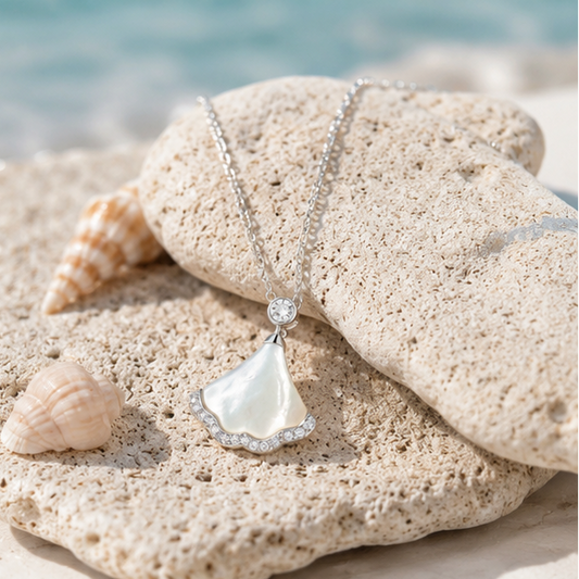 Elegant sterling silver mother of pearl pendant necklace styled on natural beach stones and seashells from the Côte Bleue collection.