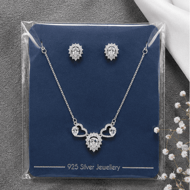 925 sterling silver Celestia Twin Hearts necklace and earrings set displayed in original protective packaging.