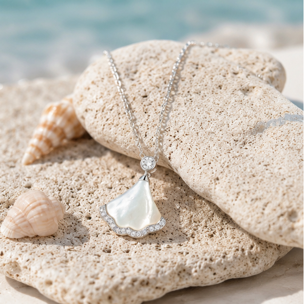 Elegant sterling silver mother of pearl pendant necklace styled on natural beach stones and seashells from the Côte Bleue collection.
