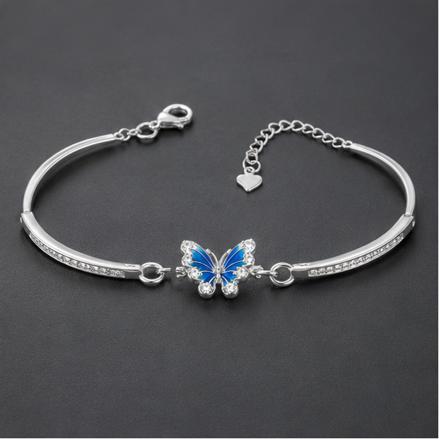 Luxury sterling silver butterfly kada bracelet with blue butterfly centerpiece displayed on a grey, black, and silver premium background.
