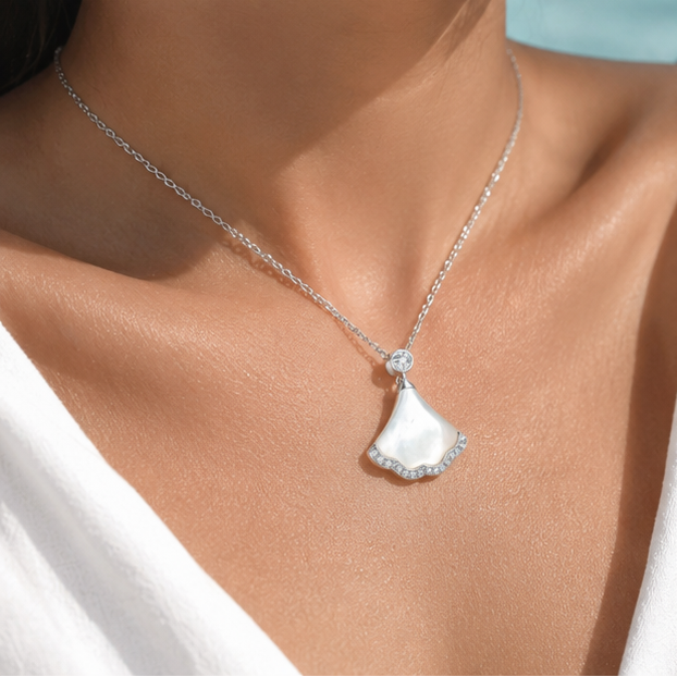 Woman wearing the Nacre Tide sterling silver mother of pearl pendant necklace for an elegant coastal-inspired look.