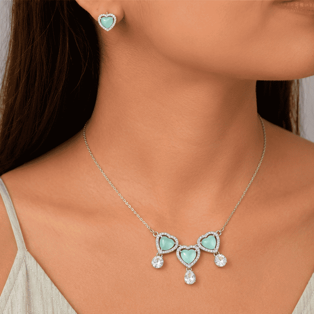 Model wearing the vrindae silver necklace set with matching heart earrings.