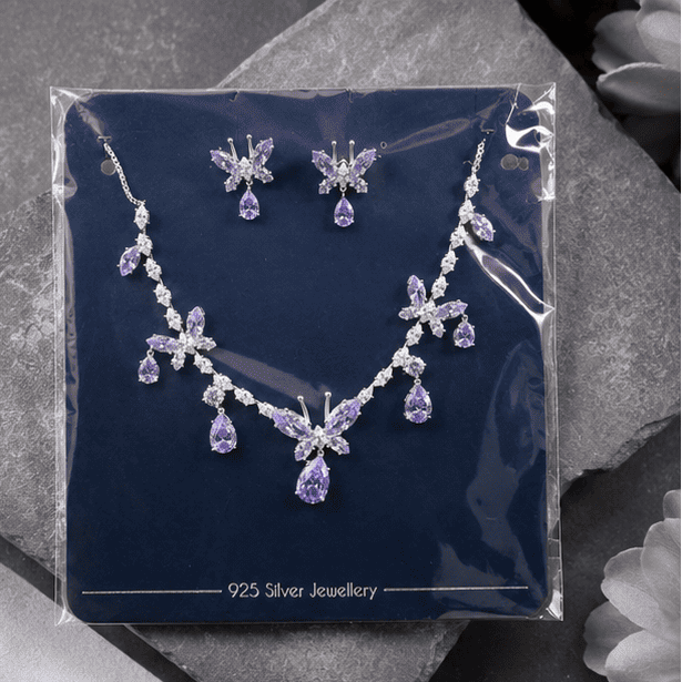 Vrindae Argente 925 sterling silver butterfly necklace and earrings set displayed in premium branded packaging with lavender crystal details.