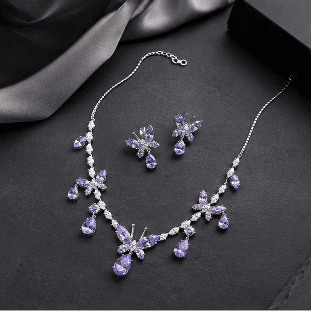 Luxury 925 sterling silver butterfly jewellery set featuring lavender marquise and pear-cut cubic zirconia stones in an elegant flat lay arrangement.